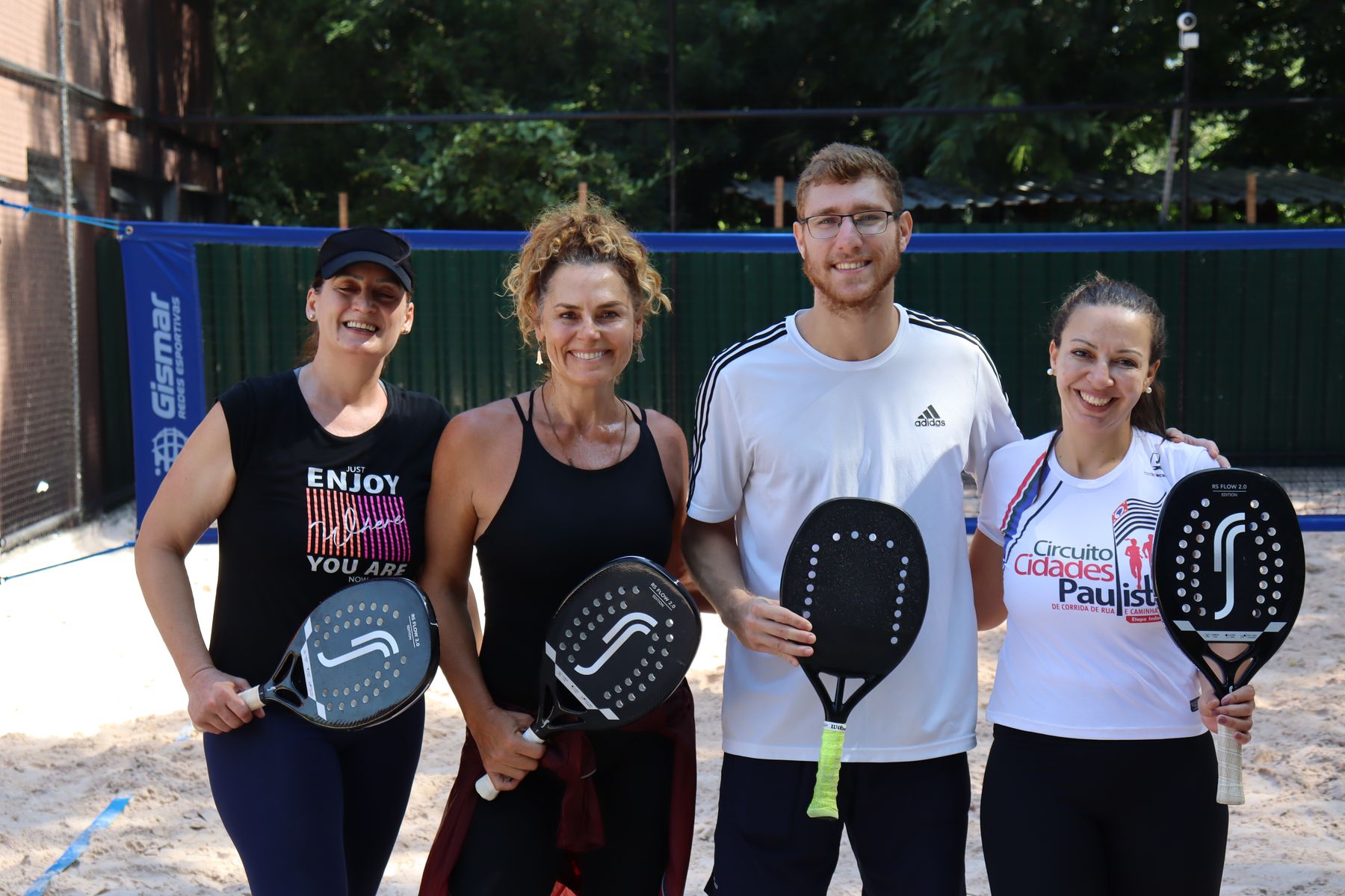 Grupo de praticantes de beach tennis com raquetes na quadra